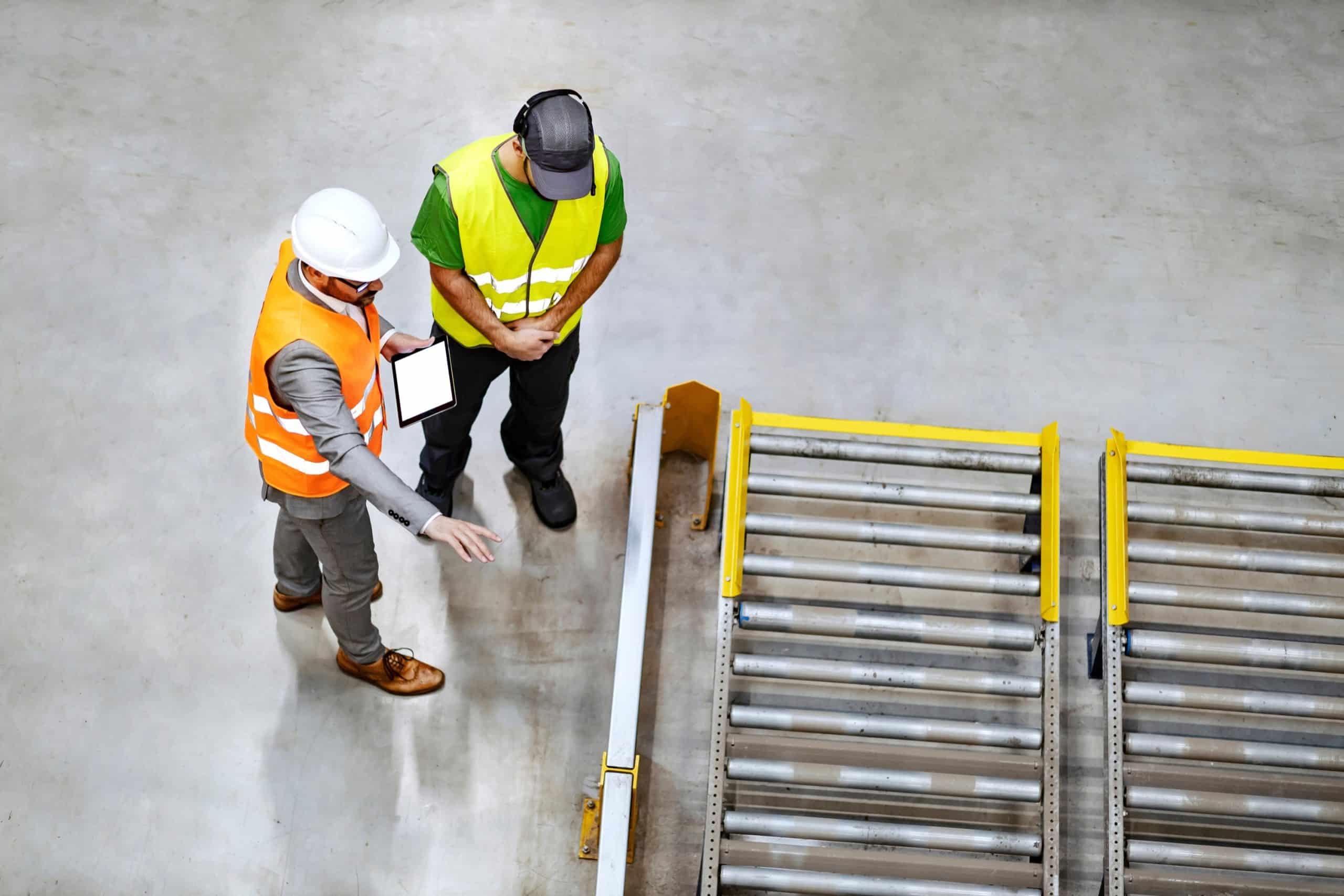 Two colleagues looking at the construction of a roller conveyor system.